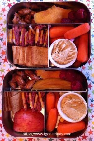 pastrami, cheese, crackers, carrots, hummus, apple, dried mango and pretzel nuggets